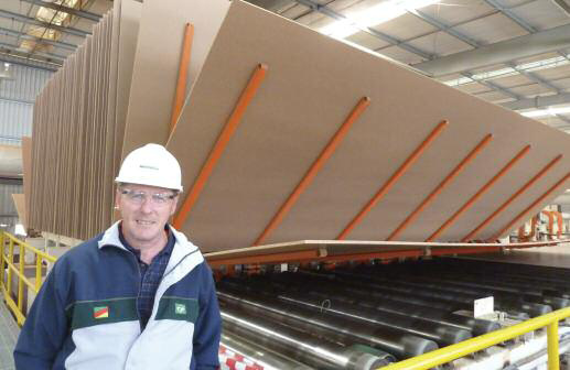 Montenegro plant manager Juan Schmidt beside the line's horizontal panel cooling wheel from Isobord Enterprises